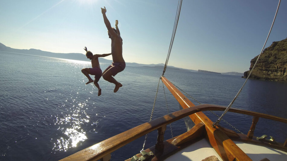 adventure travel - image of two boys jumping from a boat