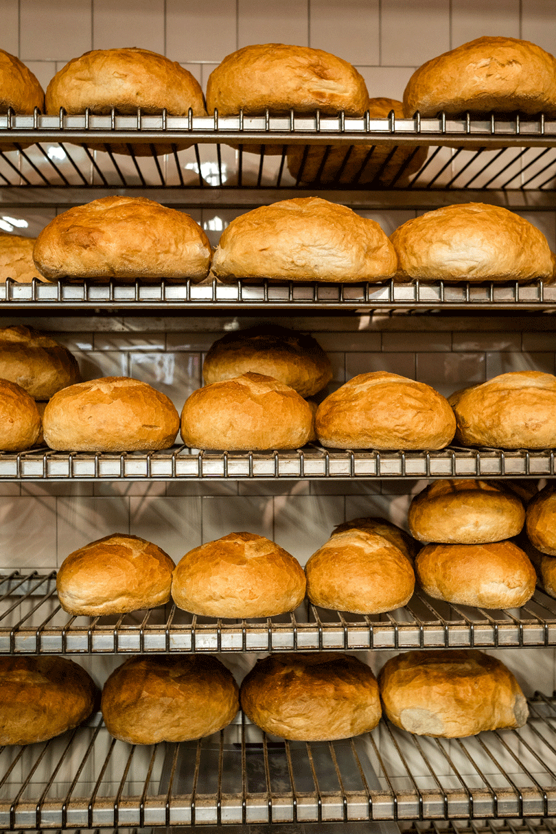 A rack of breads on a shelf in a bakery, offering the best food in the Bronx.