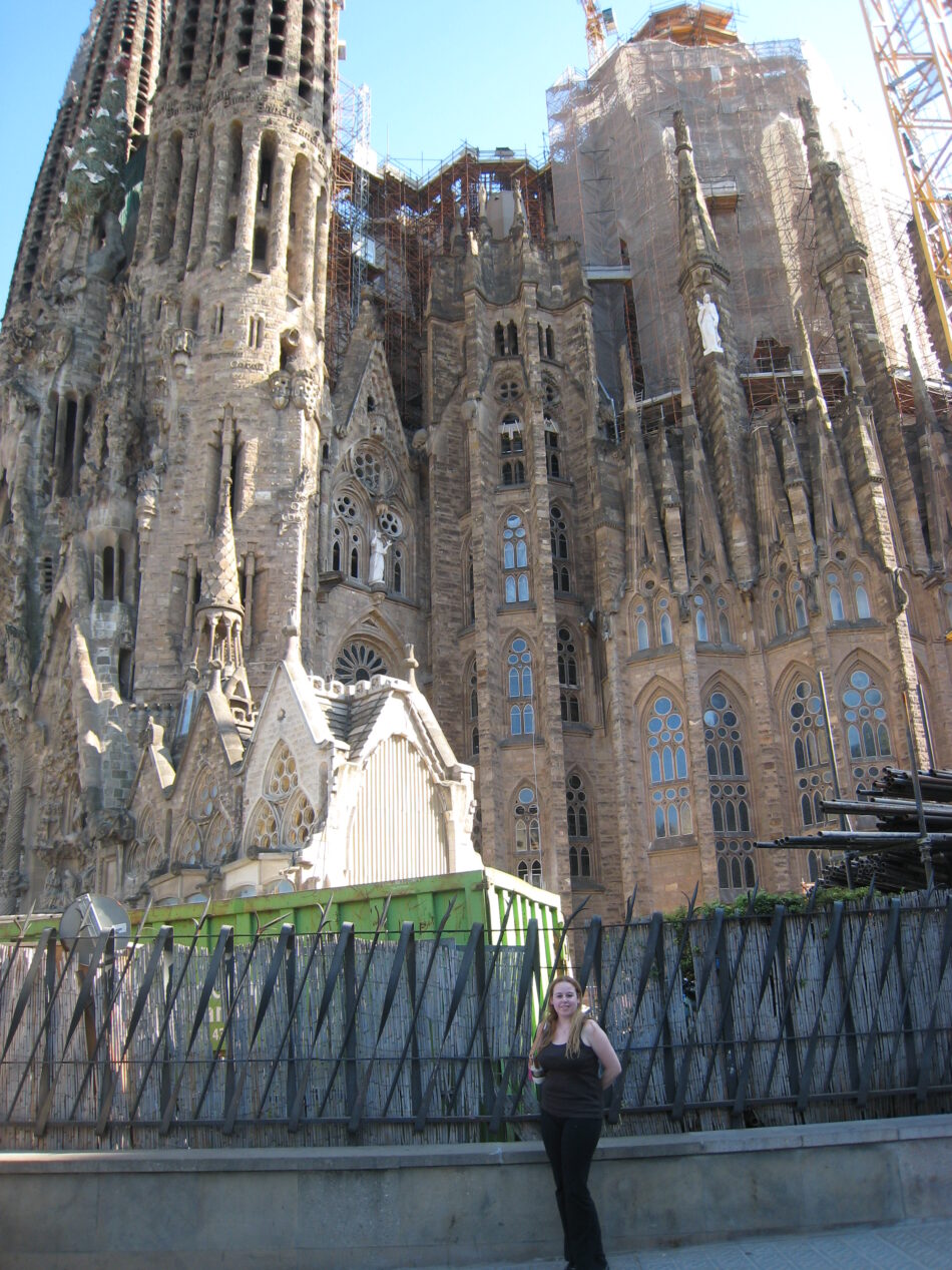 A woman standing in front of a building during her world travels.