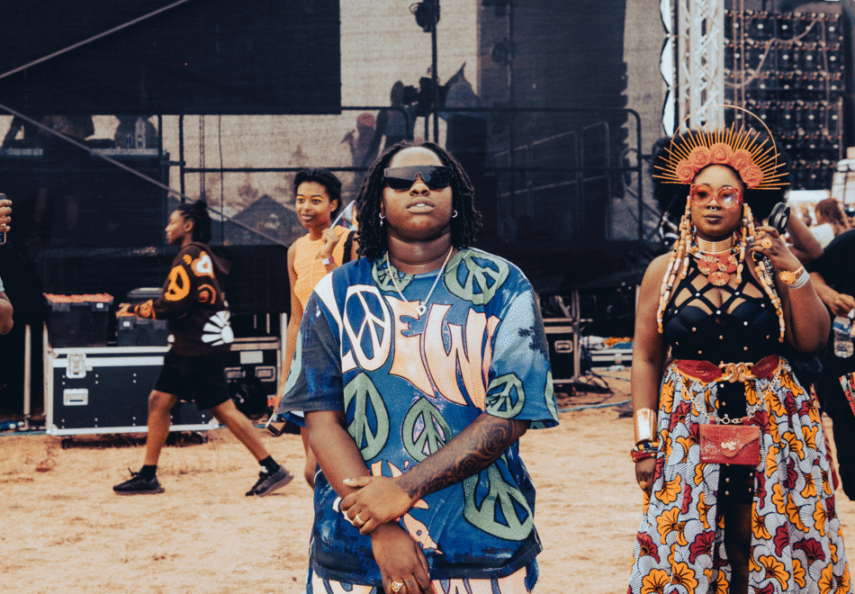 A diverse group of people standing next to each other at a concert during UK Black pride.