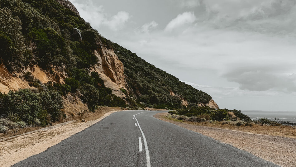 A road leading to the ocean on a cliff.