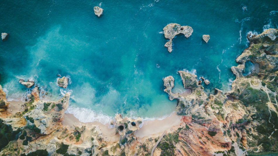 An aerial view of a beach with rocks and water in Portugal.