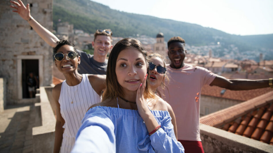 A solo traveler taking a selfie on a rooftop in Dubrovnik, Croatia.