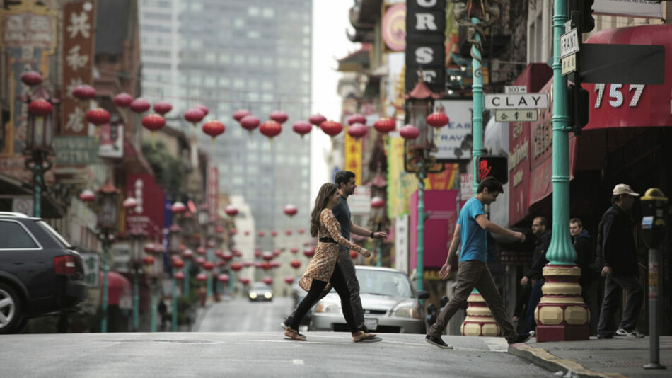 People enjoying food experiences while walking down a street in San Francisco.