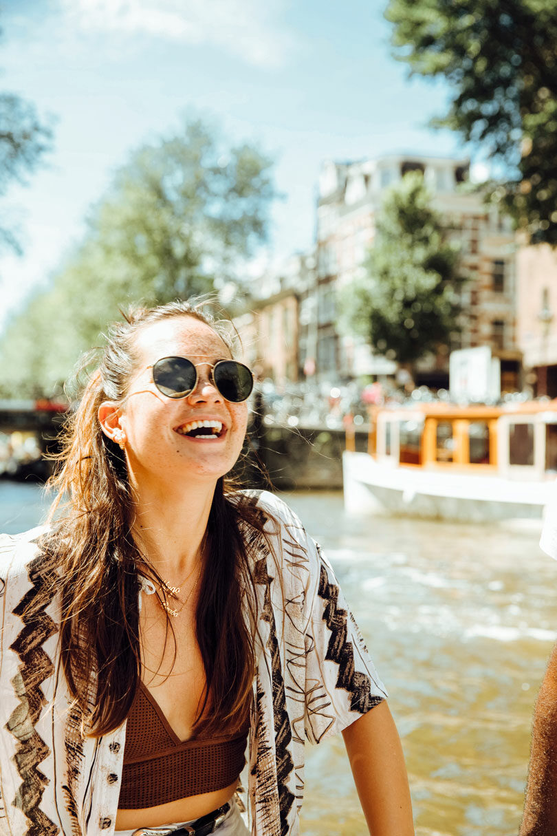 Two people laughing on a boat in one of the happiest countries, Amsterdam.