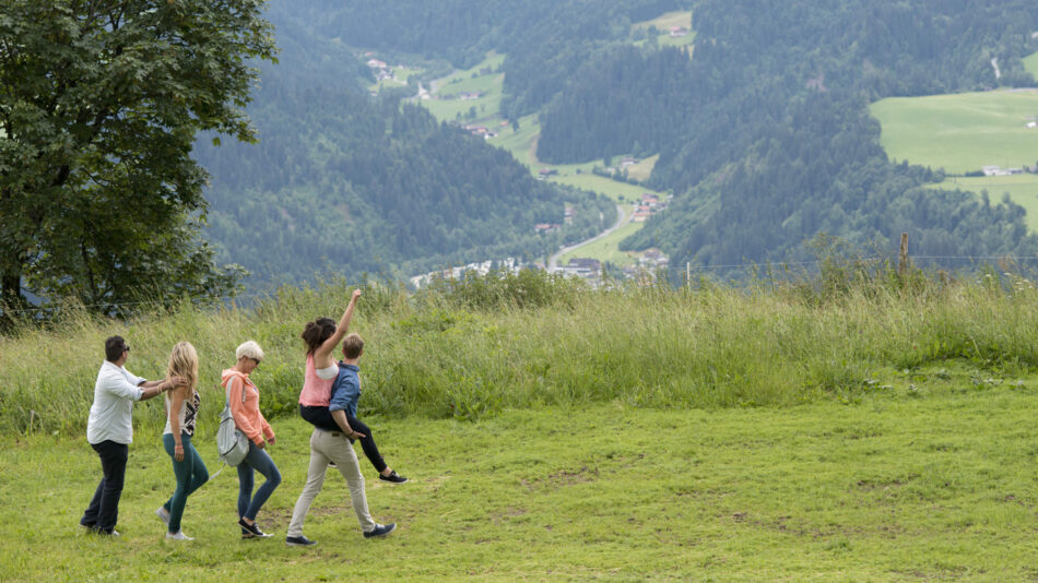 A group of people practicing the Nordic way of life while standing on a grassy hill.