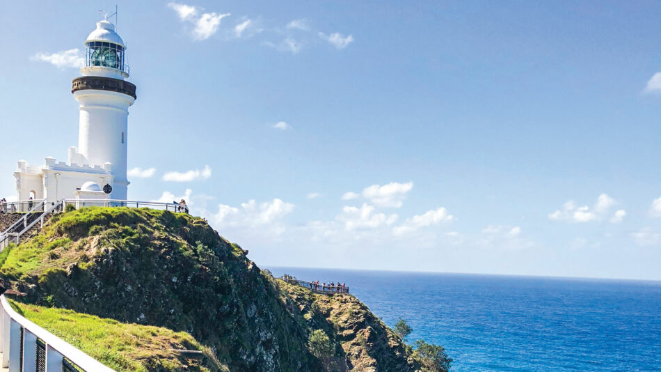 A lighthouse sits on top of a cliff overlooking the ocean.