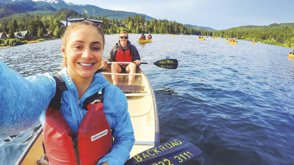 A group of people paddling in a canoe on a lake.