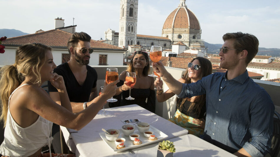 A group of people toasting on a rooftop in Florence with their tour manager.