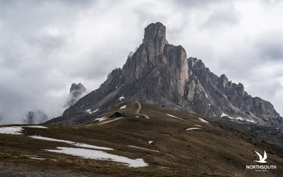 A mountain in Italy with a small cabin on top.