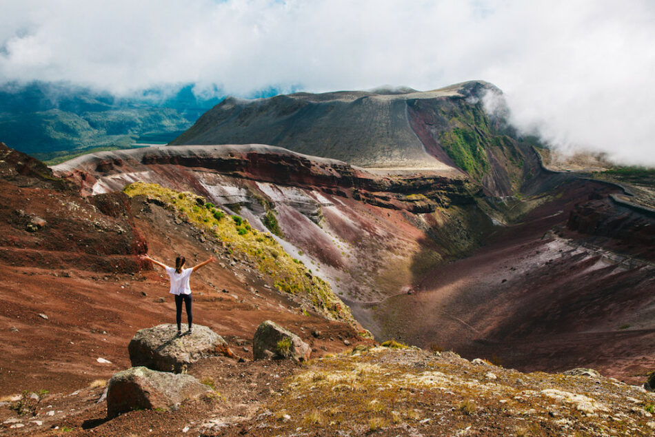 A man with a positive attitude standing on top of a mountain.