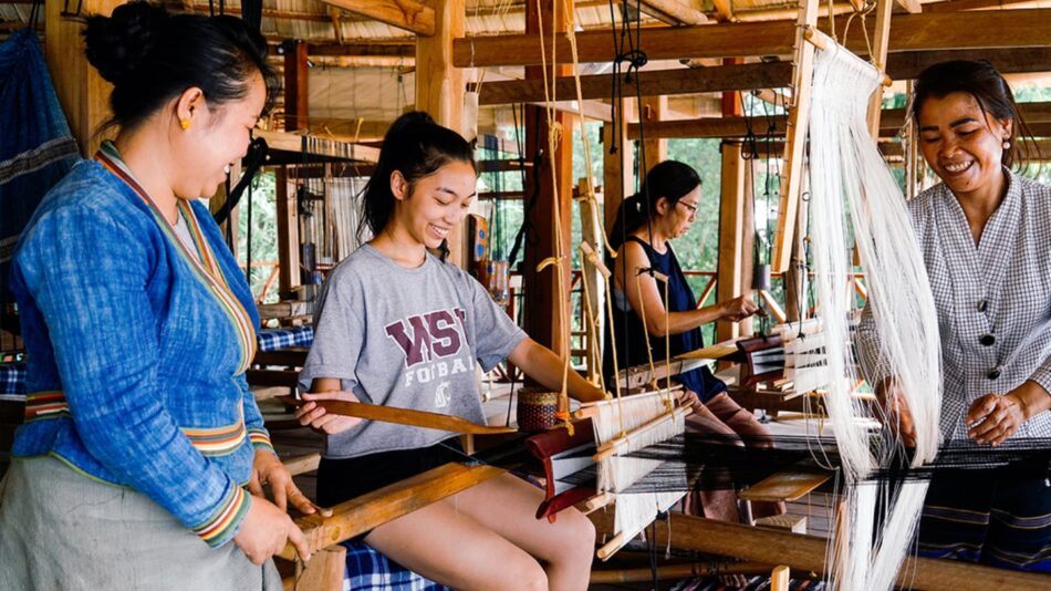 In celebration of Women's History Month, a diverse group of women come together to skillfully work on a weaving loom.