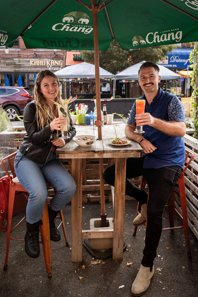 A man and a woman savoring the best food at a table in Queens.