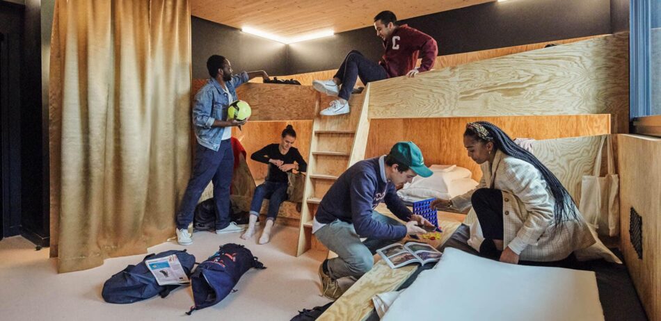 A group of people in a room with bunk beds.