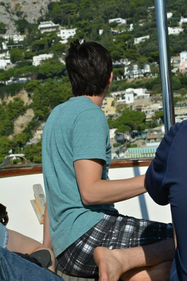 A man sitting on a boat, possibly traveling to Italy.