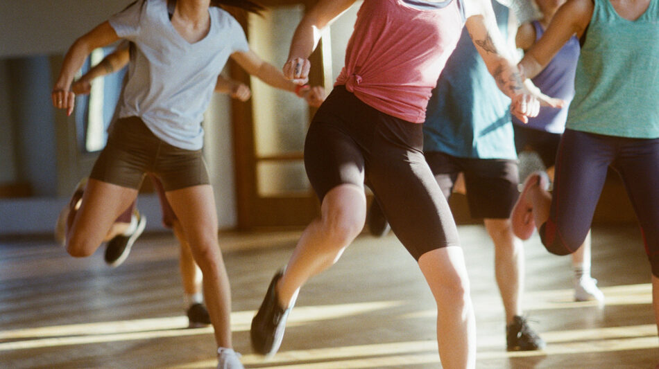 A group of people running in a gym.