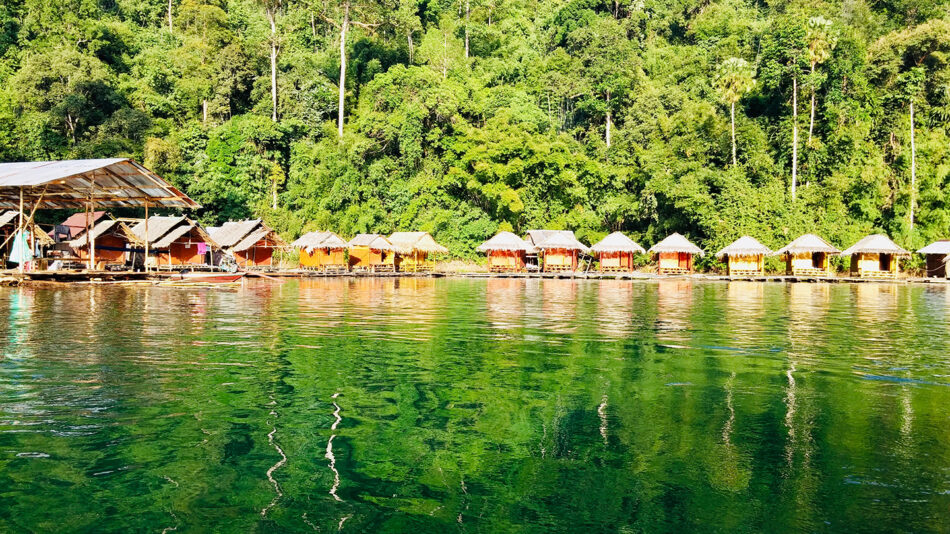 A group of huts on a lake in a forest, located in Thailand.