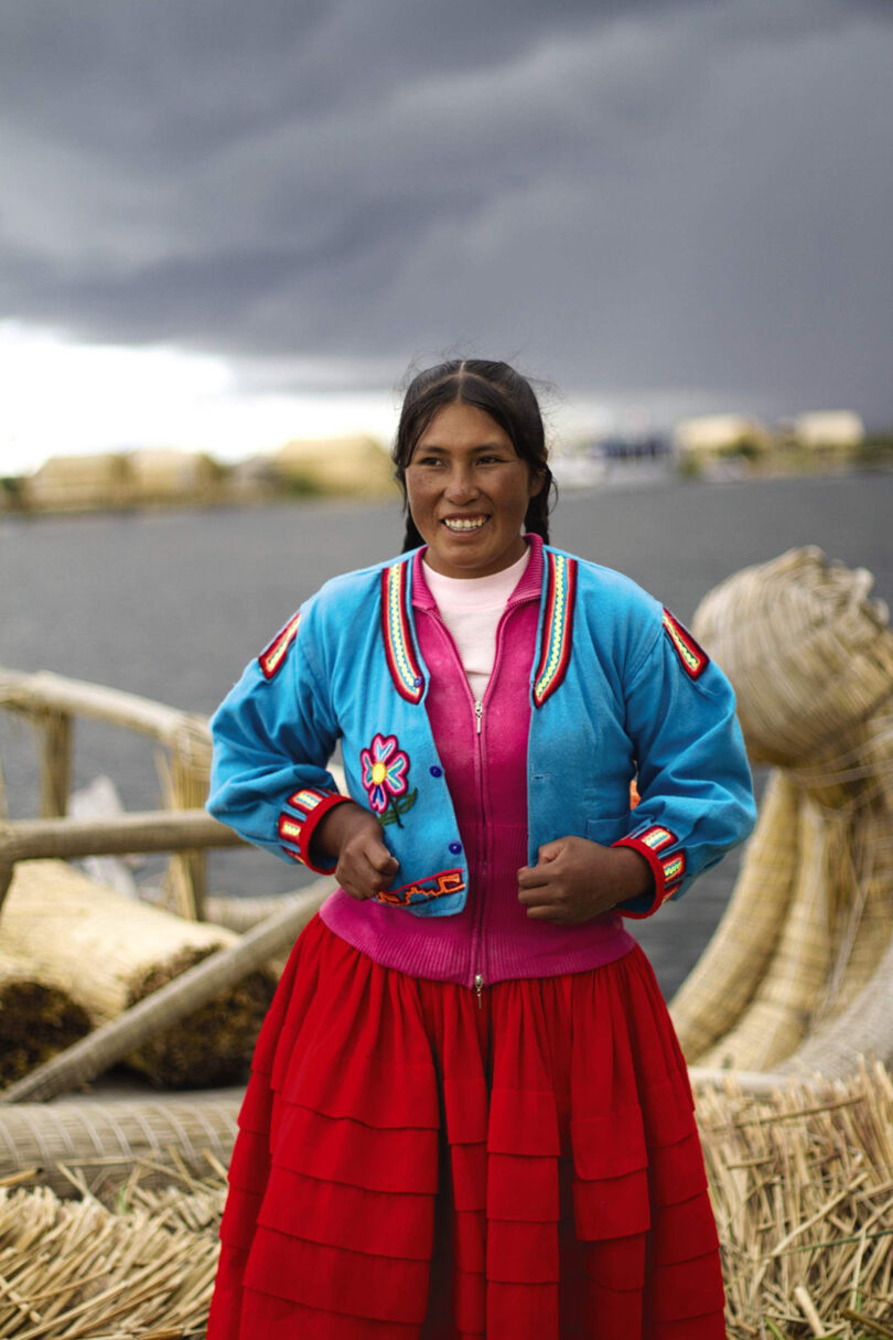 A woman wearing a red and blue skirt at Lake Titicaca.