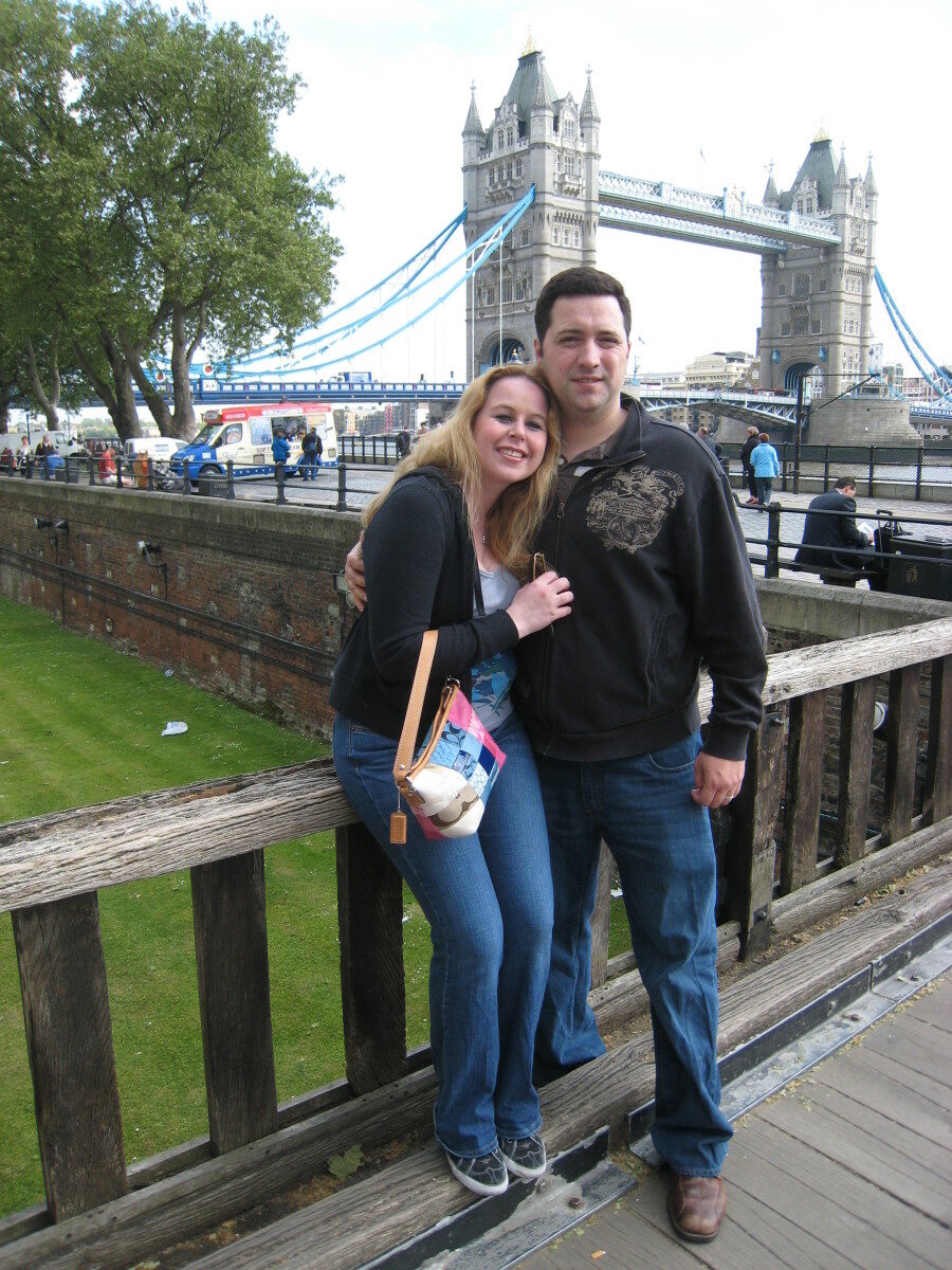 A man and a woman posing for a picture while traveling around the world.