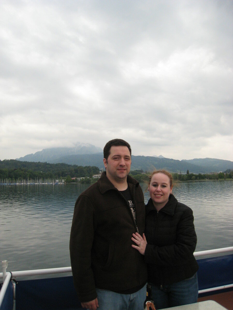 A man and a woman traveling around the world, standing on a boat.