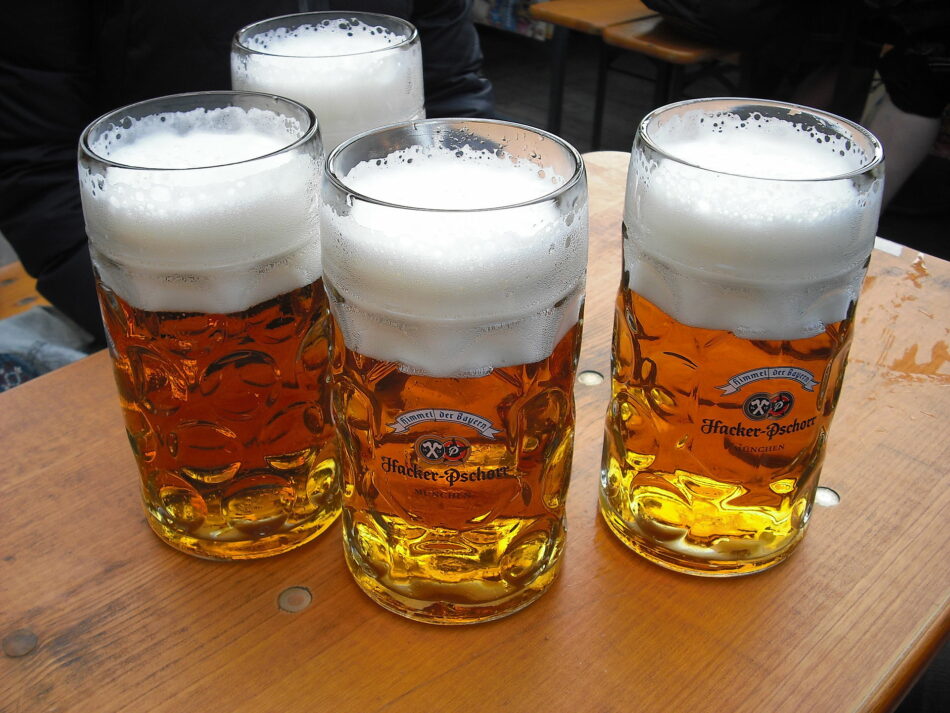 Four glasses of beer on a wooden table.