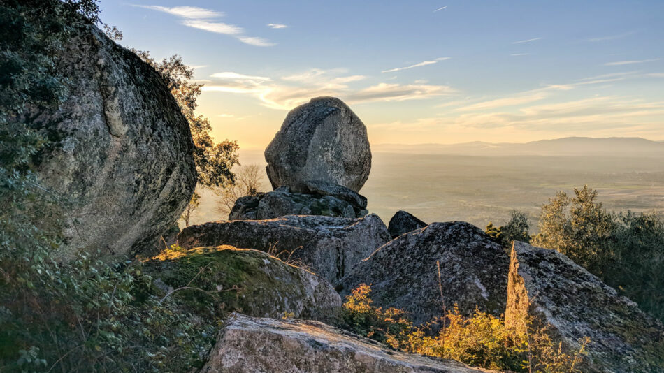 A large rock sits on top of a hill overlooking a valley, potentially serving as a house of the dragon filming location.