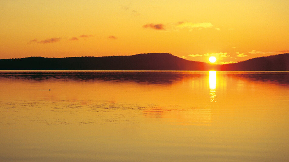 Image of the midnight sun over a lake