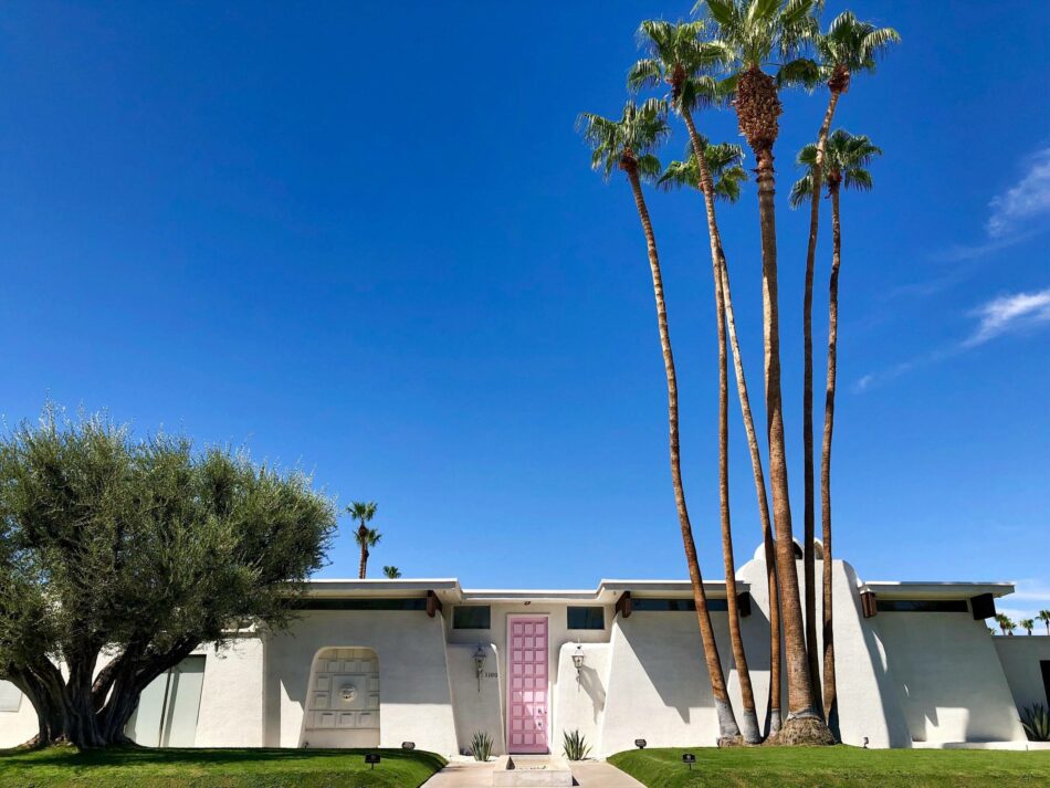 A house with palm trees in front of it.