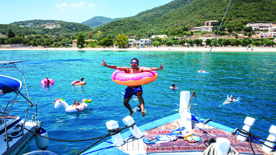 A man is jumping off a boat in the water.