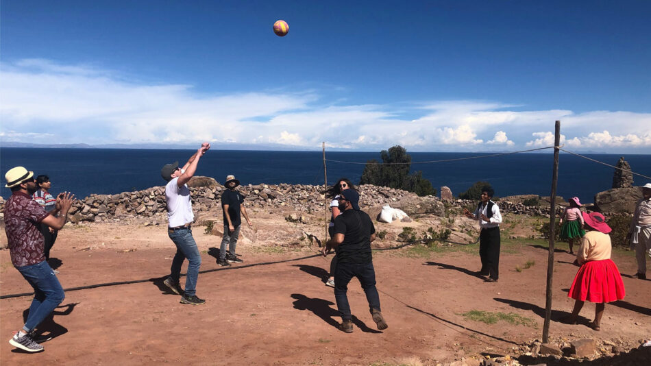 A group of people playing sports with locals on Lake Titicaca on Contiki's Peru Panorama trip