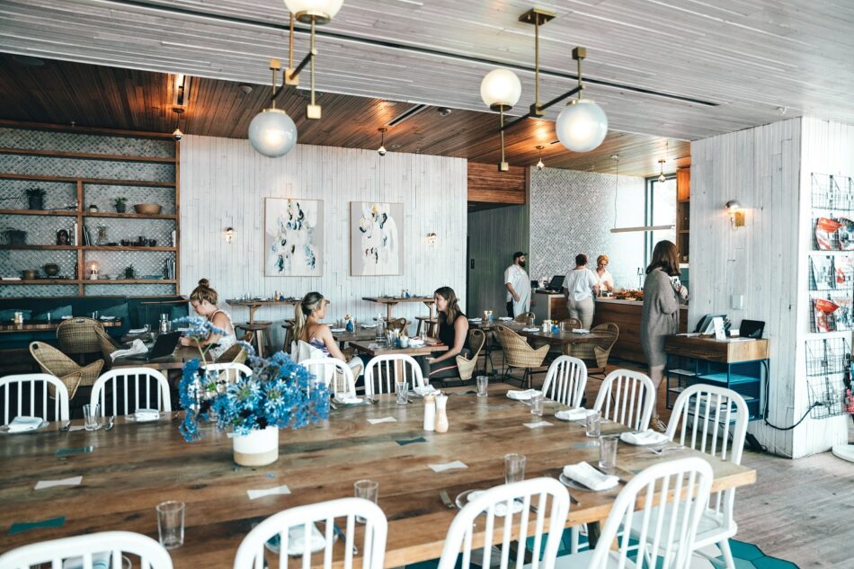 The interior of a restaurant with white tables and chairs.