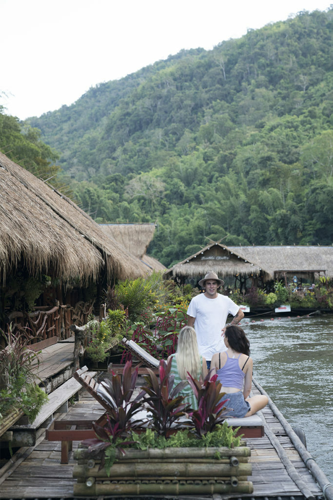 A group of people on a Contiki trip sitting on a dock.