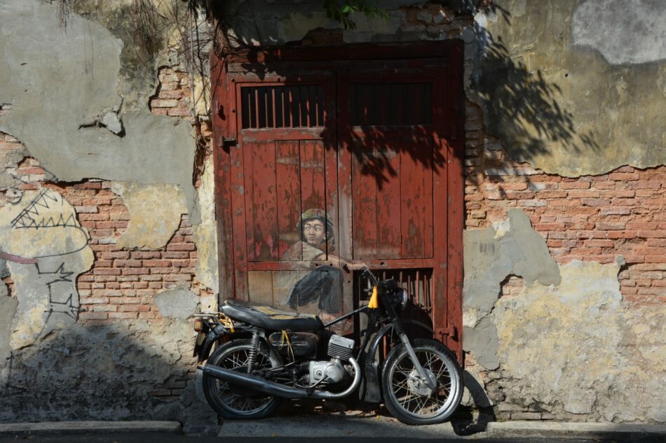 A motorcycle parked in front of a door, showcasing one of the best street art in the world.