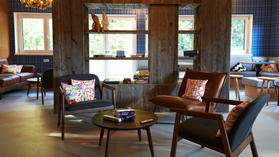 A living room with a table and chairs on a Contiki trip.