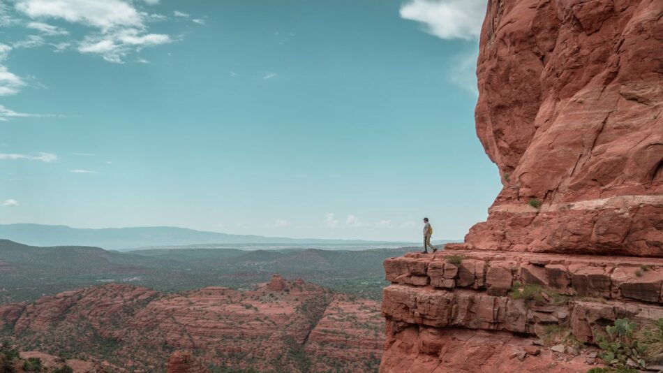 A man standing on the edge of a cliff in sedona, arizona.