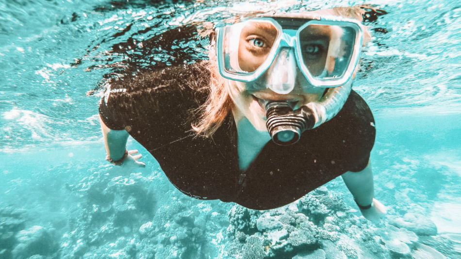 A woman enjoying snorkeling in the ocean near Cairns, Australia.