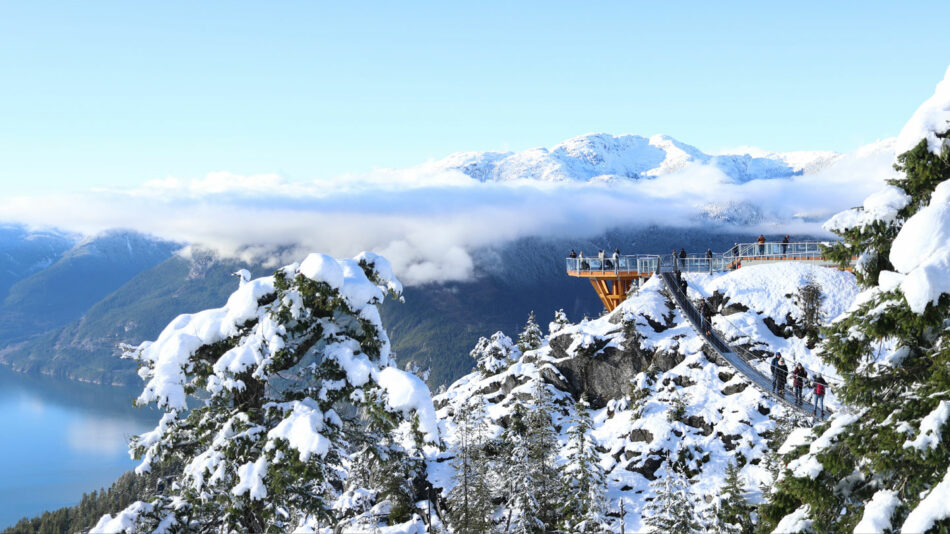 A group of people standing on top of a snow covered mountain.