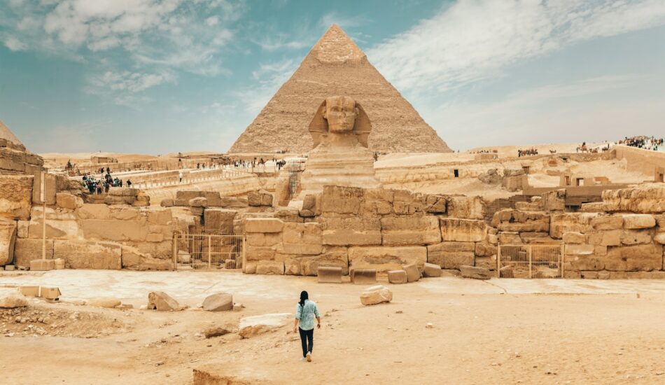 Person walking toward the Pyramids of Giza, Egypt