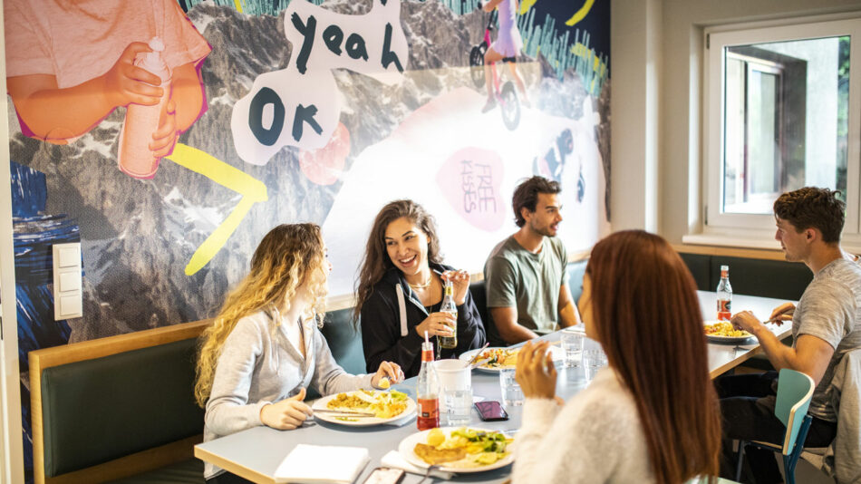 A group of people sitting at a table eating food.