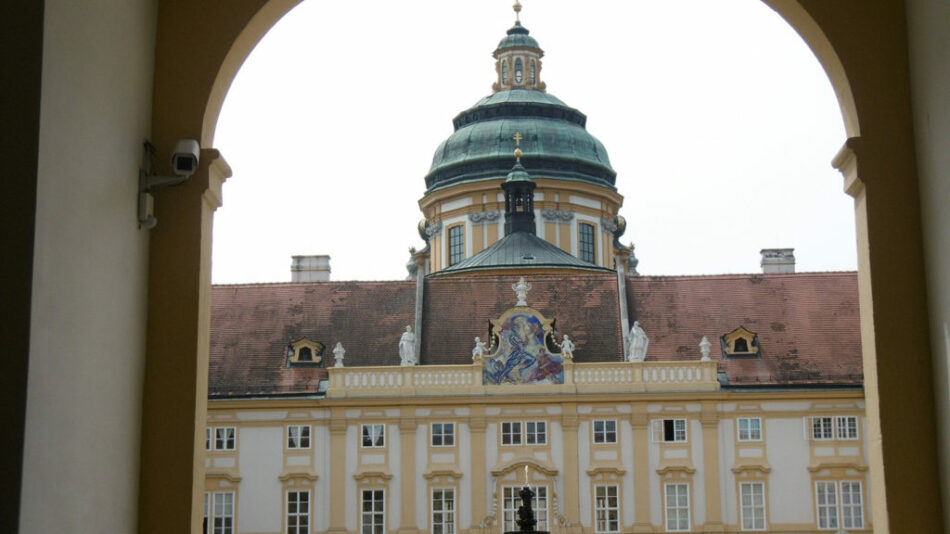 A large building with a clock tower, popular as one of the things to do in Austria.