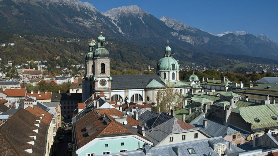 An aerial view of a city with mountains in the background, showcasing the breathtaking beauty of Austria.