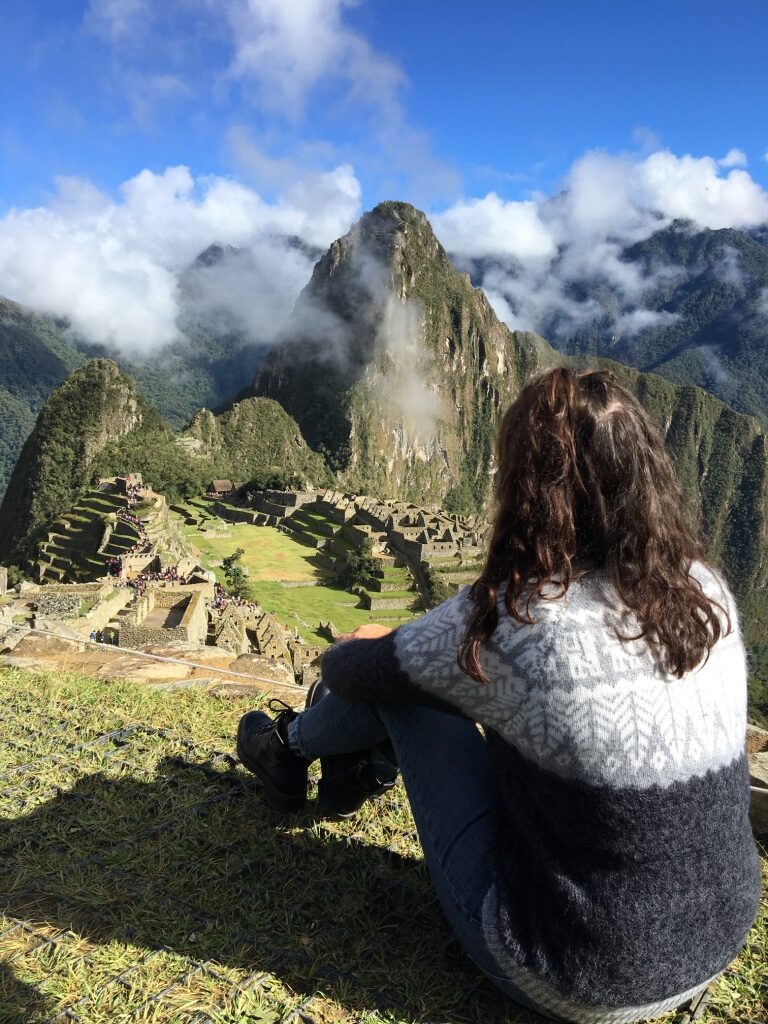 A woman sitting on the ground in Machu Picchu.