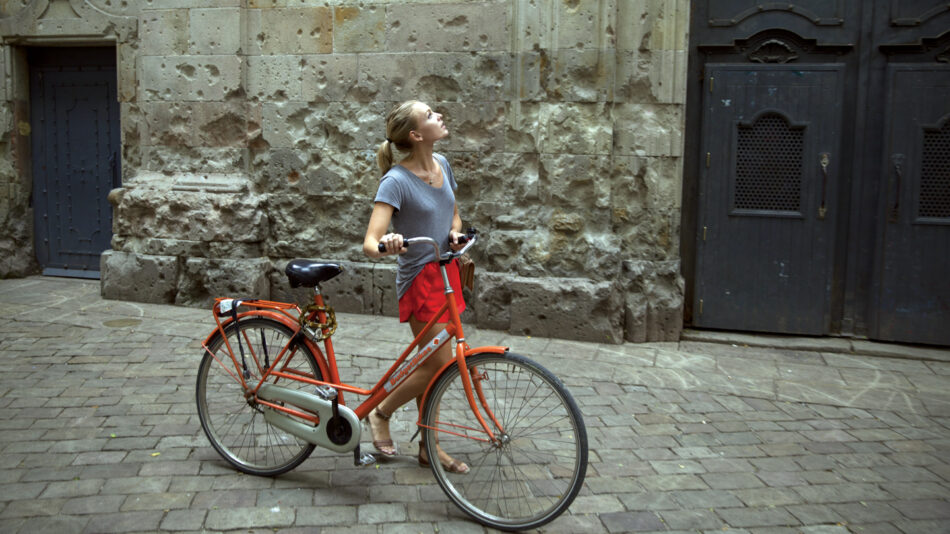 self improvement - image of a girl pushing a bike through a street in Barcelona