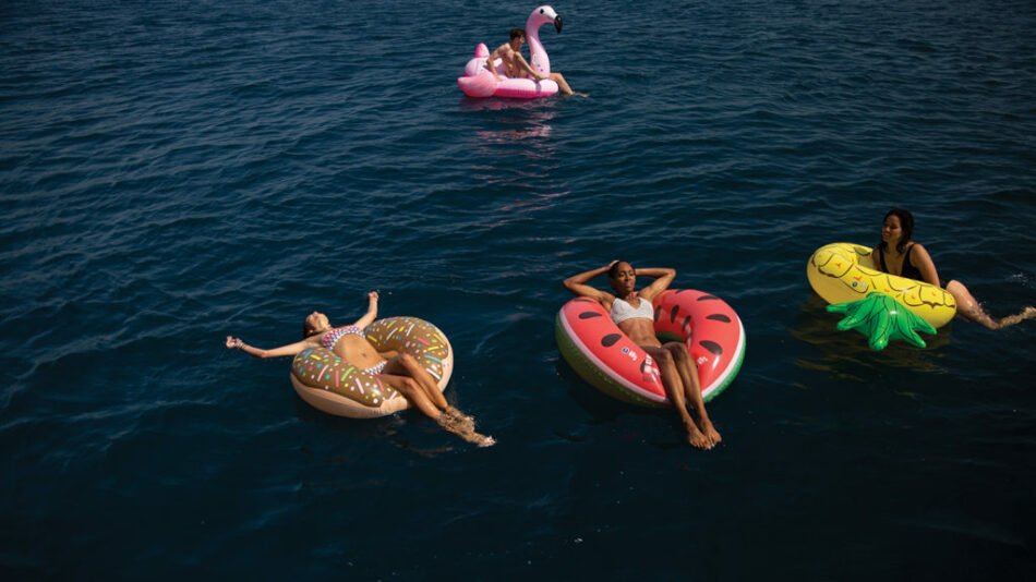 A group of women embracing their wanderlust gene while floating on inflatable rafts in the ocean.