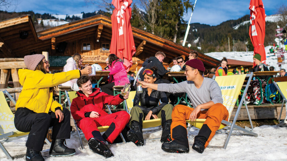 A group of people sitting on chairs in the snow.