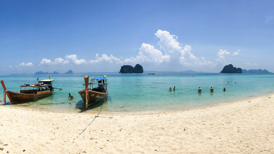 One of the most beautiful destinations in Thailand, a sandy beach adorned with boats.