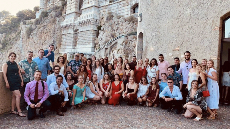 A real travel love story captured with a group of people posing for a picture in front of a castle.