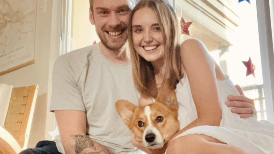 A real travel story featuring a man, woman, and their beloved corgi dog posing together.