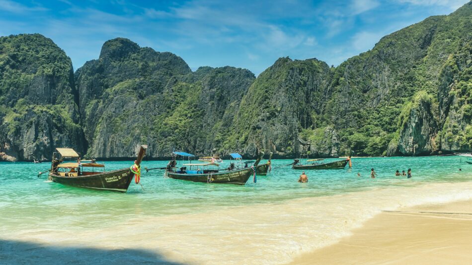 Boats docked on a beach in Phi Phi Island, Thailand during Thai island hopping.