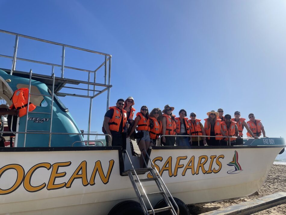 A group of people standing on a boat during an ocean safari.